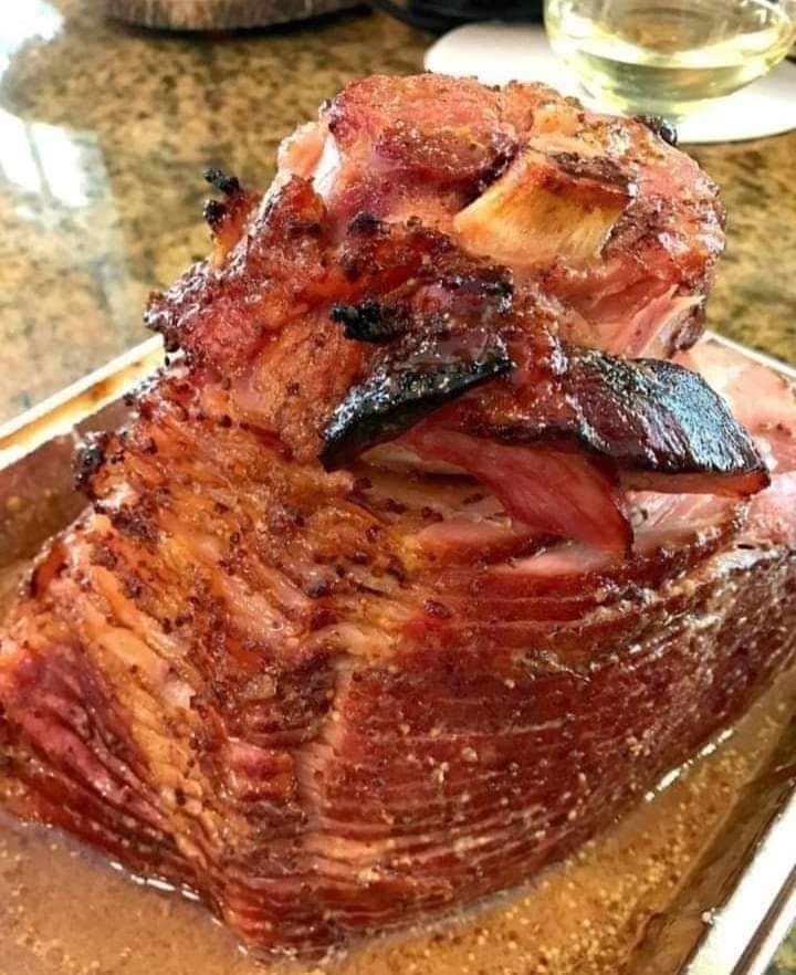 Baked ham, cooked low and slow with brown sugar, mustard, and cola has